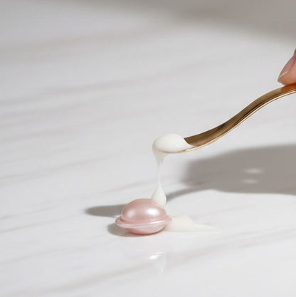 Gold spoon with a small amount of cream on a white surface