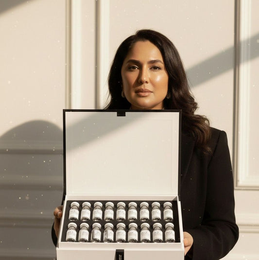 Woman Erum Alam holding a large white box with multiple small containers inside against a neutral background